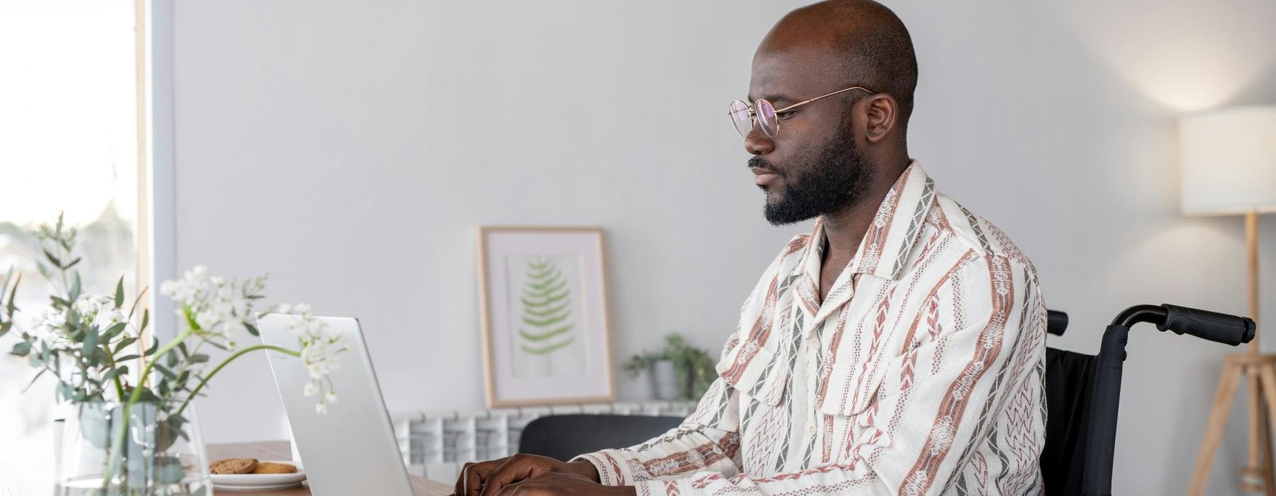 a man sitting at a table using a laptop